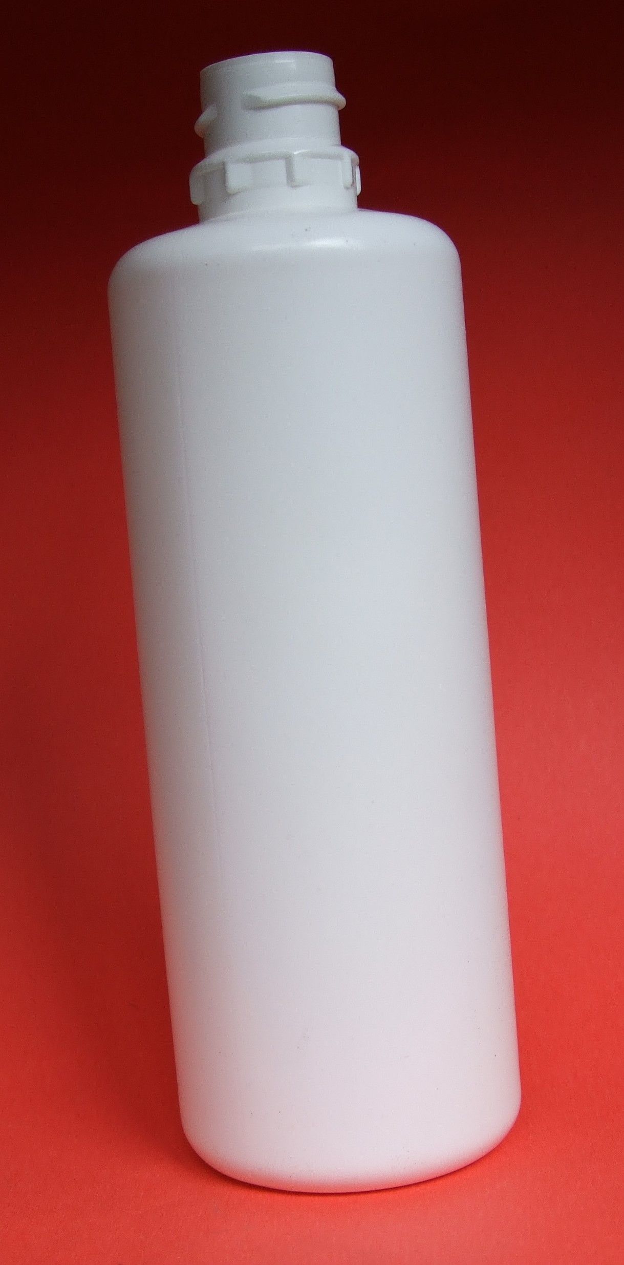 Bouteille en plastique blanc à col étroit sur fond rouge