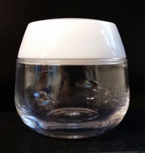 Bocal en verre transparent avec couvercle blanc sur fond sombre