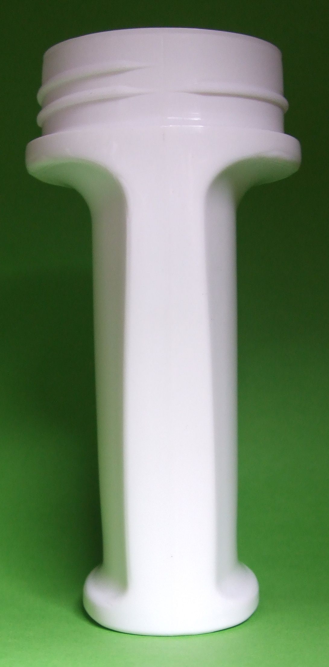 Objet en plastique blanc en forme de bobine sur fond vert