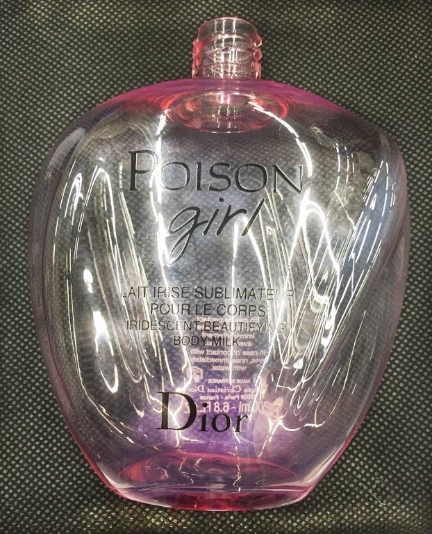 Flacon de parfum Pink Dior Poison Girl sur fond texturé sombre