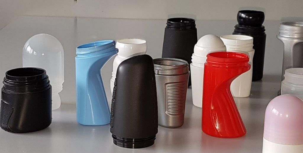 Assortiment de petits récipients et de bouteilles noirs, bleus, gris, blancs, rouges et roses sur une étagère