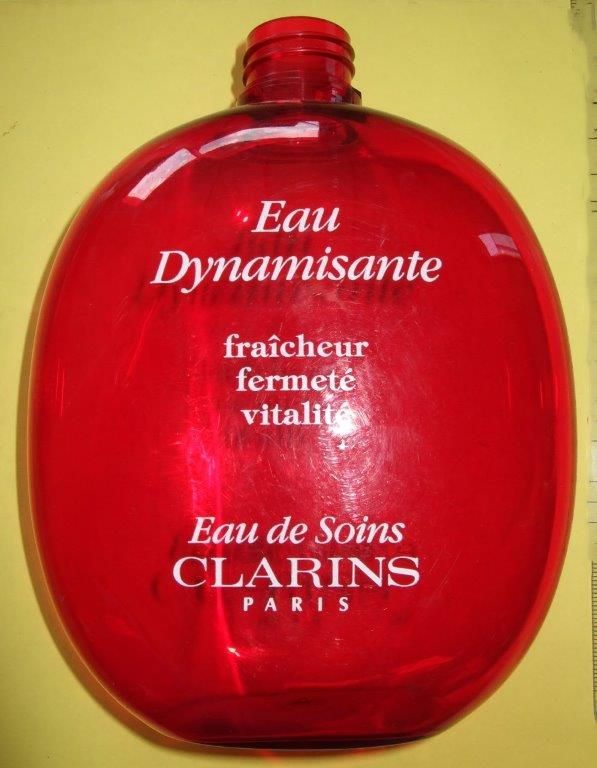 Flacon rouge de parfum Eau Dynamisante de Clarins avec texte blanc sur fond jaune