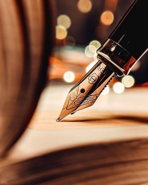 Escritura con pluma estilográfica sobre papel con un suave fondo bokeh.