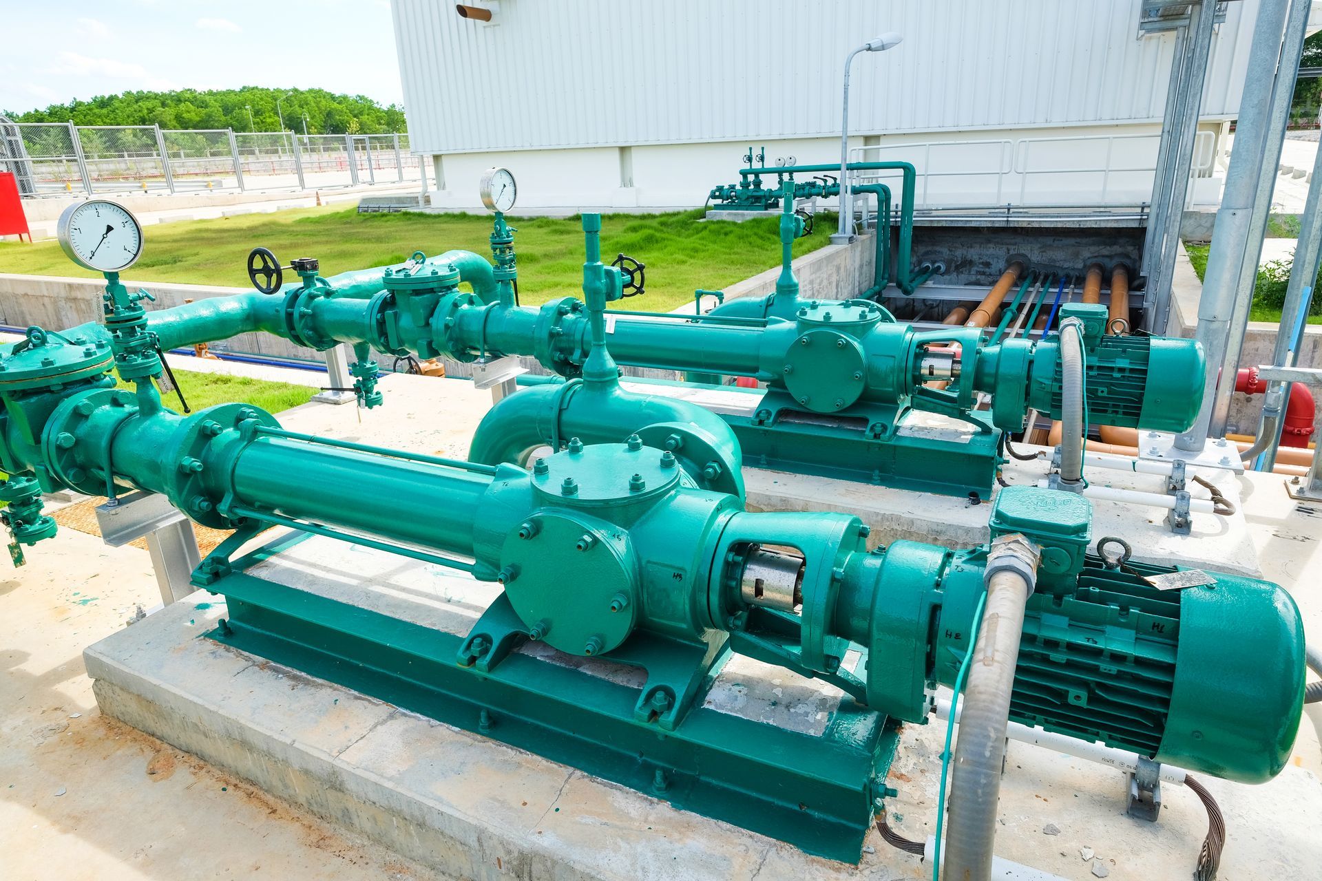 Pompes industrielles vertes avec tuyaux et manomètres intégrés.