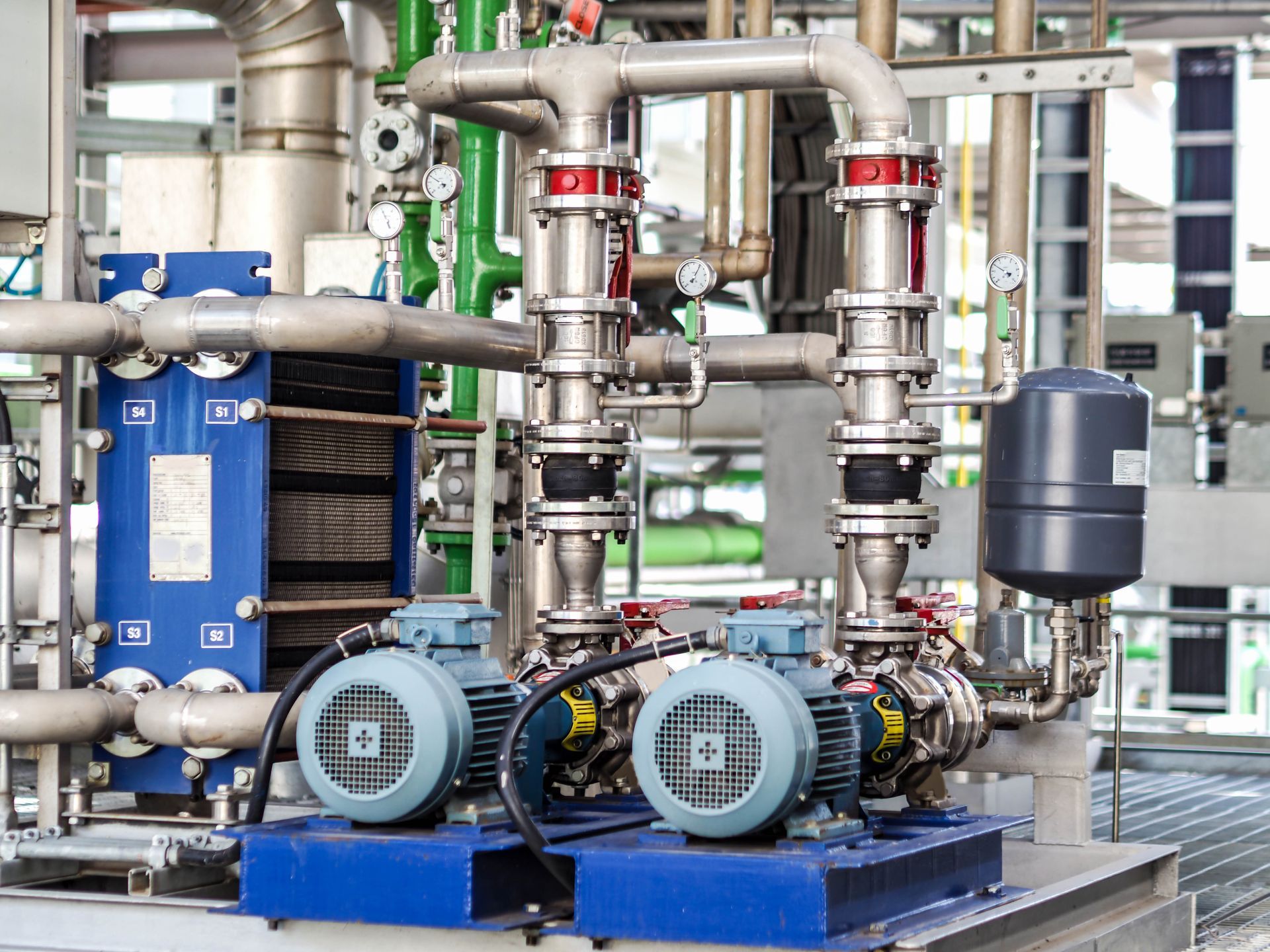 Machines industrielles avec deux pompes électriques et canalisations raccordées dans une installation.