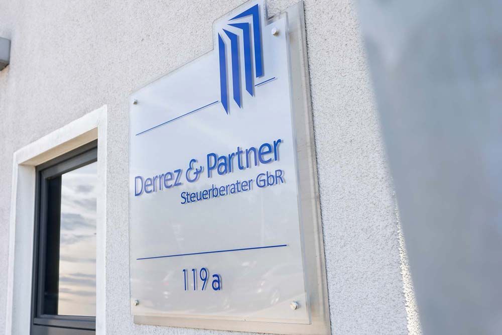 Ein Schild an der Seite eines Gebäudes mit der Aufschrift Derrez & Partner