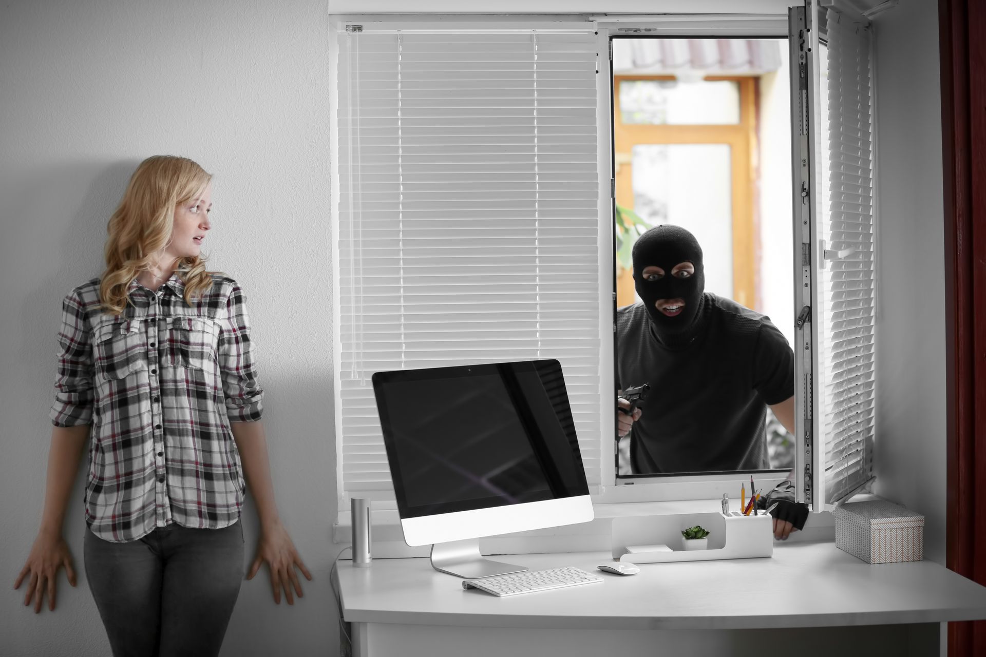 Un cabrioleur tantant d'accèder au bureau par la fenêtre