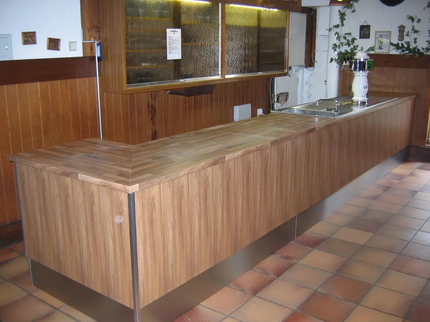 Bar aus Holz mit Edelstahlgestell in einem Restaurant.