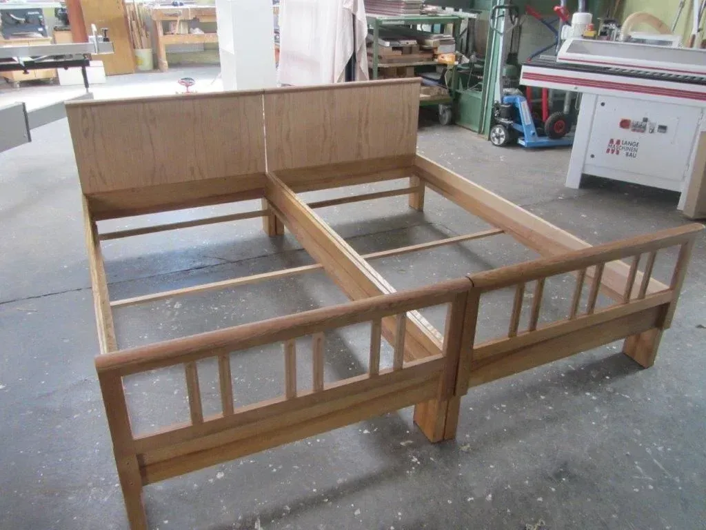 In einer Werkstatt entsteht ein Bettgestell aus hellbraunem Holz.