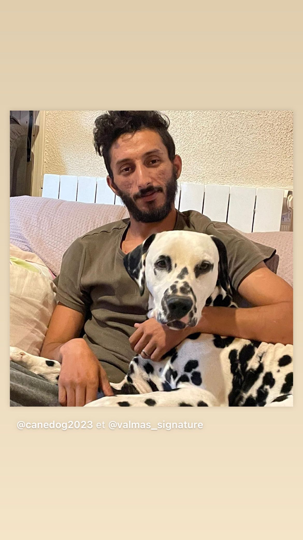 Éleveur assis dans un canapé avec un dalmatien allongé à côté de lui
