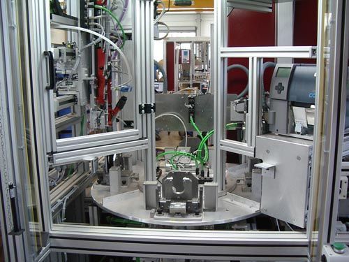 Eine automatisierte industrielle Montagestation mit einer drehbaren Metallplattform und einer Aluminiumrahmenkonstruktion.