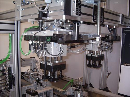Mehrachsige Industriemaschine mit pneumatischen Zylindern und silbernen Metallkomponenten im Laborumfeld