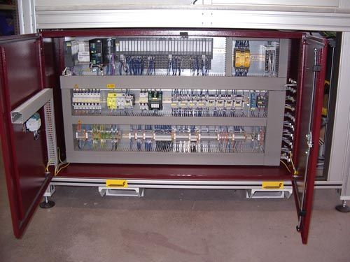 Offener Schaltschrank mit DIN-Schienen, Klemmenblöcken und Verdrahtung im Metallgehäuse