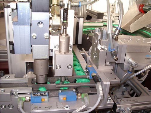 Nahaufnahme Industriemaschine verarbeitet Grünteile auf Förderband mit Komponenten und Sensoren