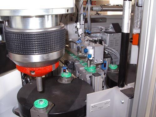 Nahaufnahme Fertigungsmaschine mit rotierender schwarzer Plattform, Bauteilen und rotem Kopf