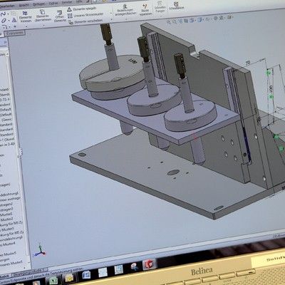 Eine 3D-CAD-Zeichnung auf einem Laptop-Bildschirm, die eine mechanische Baugruppe mit einem Sockel, einer vertikalen Stütze 