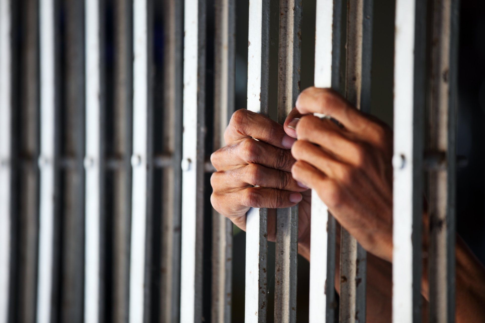 Mains qui tiennent des barreaux de prison pour signifier le droit pénal