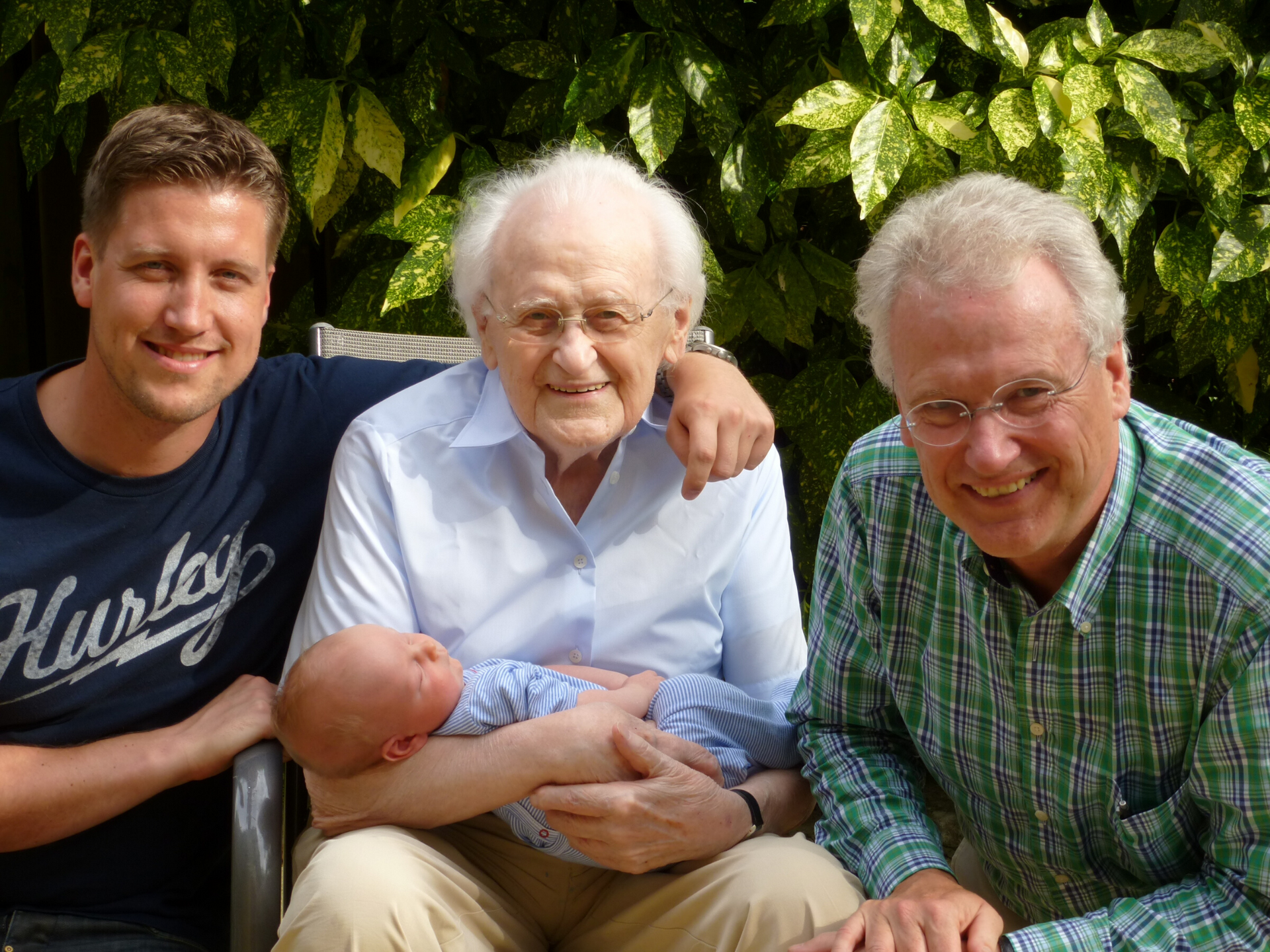 A man wearing a hurley shirt is holding a baby