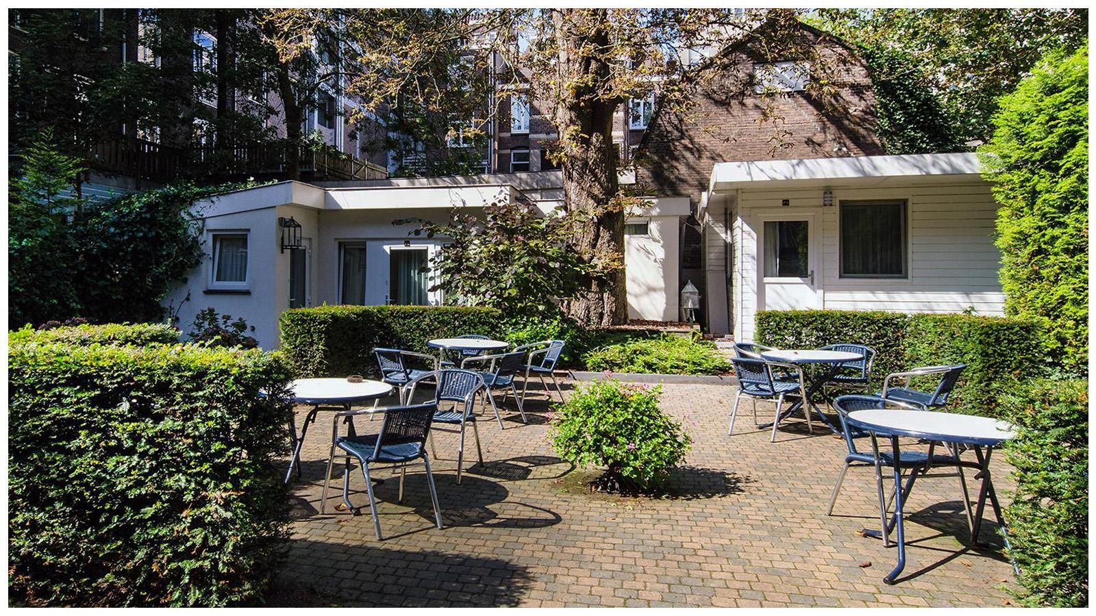 A white house with tables and chairs in front of it
