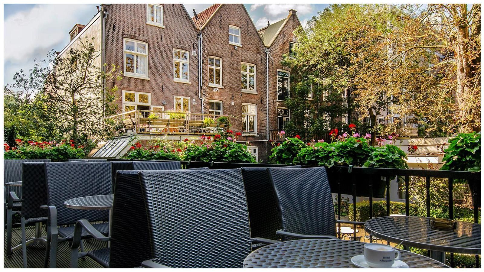A table with a cup of coffee on it in front of a brick building.