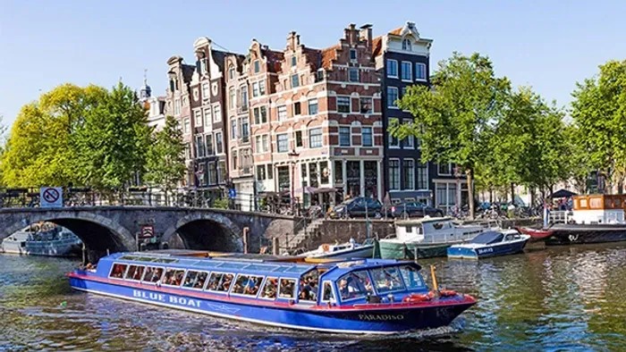 A boat is floating on a river in front of a bridge.