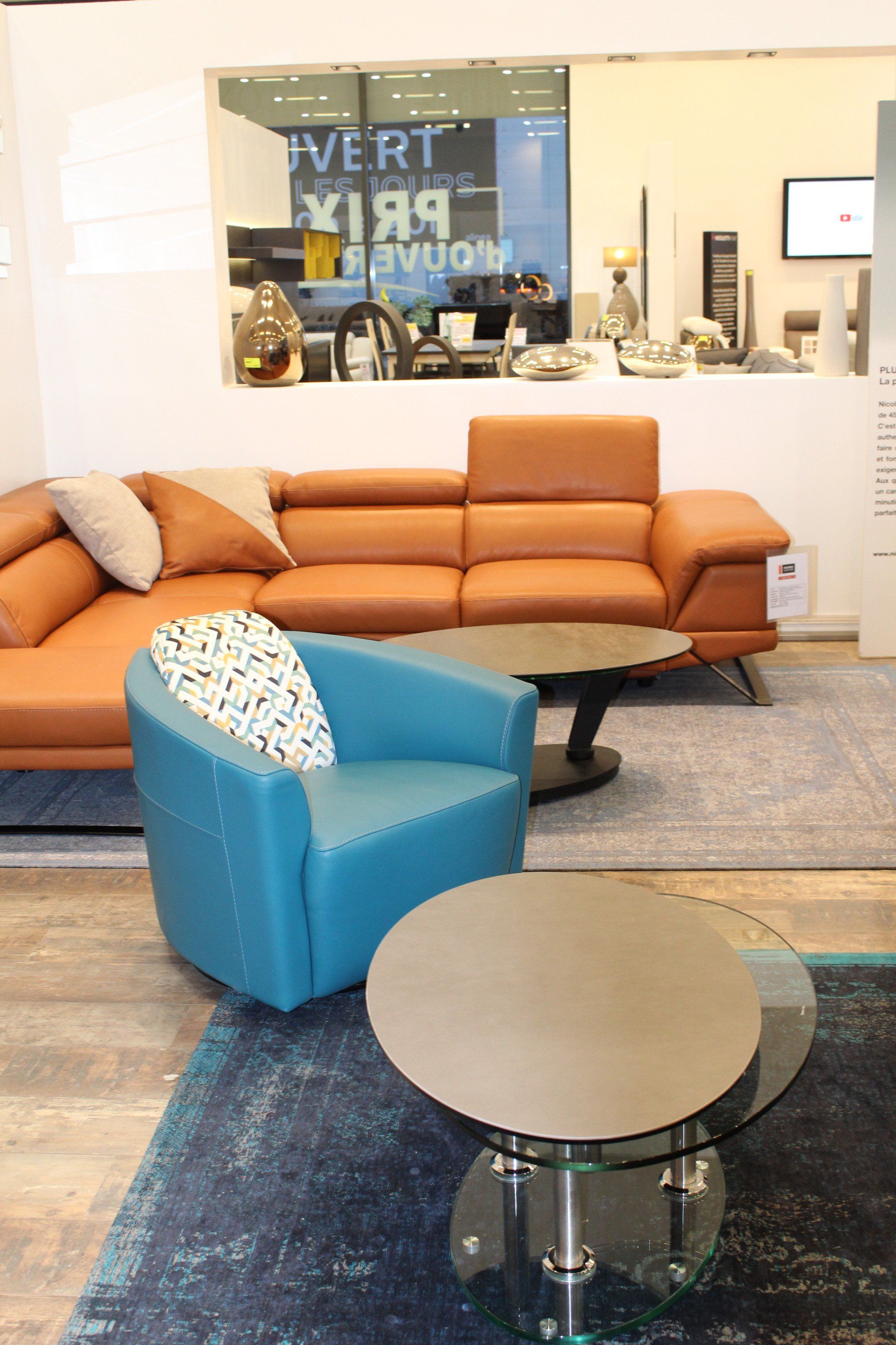 Fauteuil bleu en cuir avec oreiller devant table basse