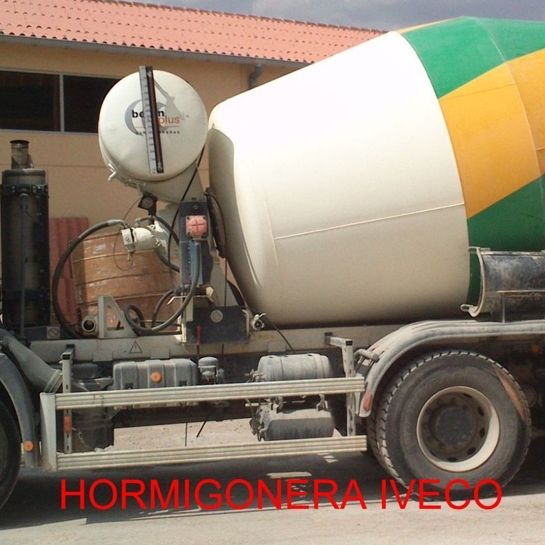 Un camión hormigonera iveco está estacionado frente a un edificio