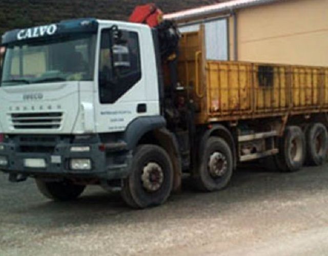 Un camión calvo está estacionado frente a un edificio