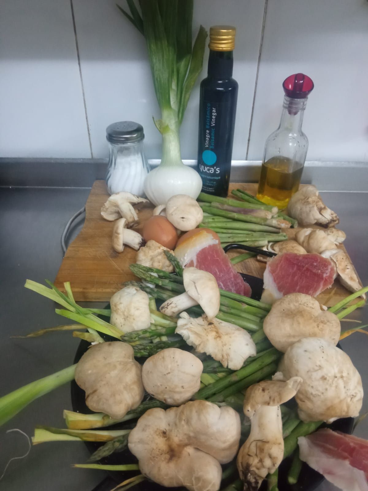 Ingredientes crudos, como champiñones, espárragos, cebolla, carne curada