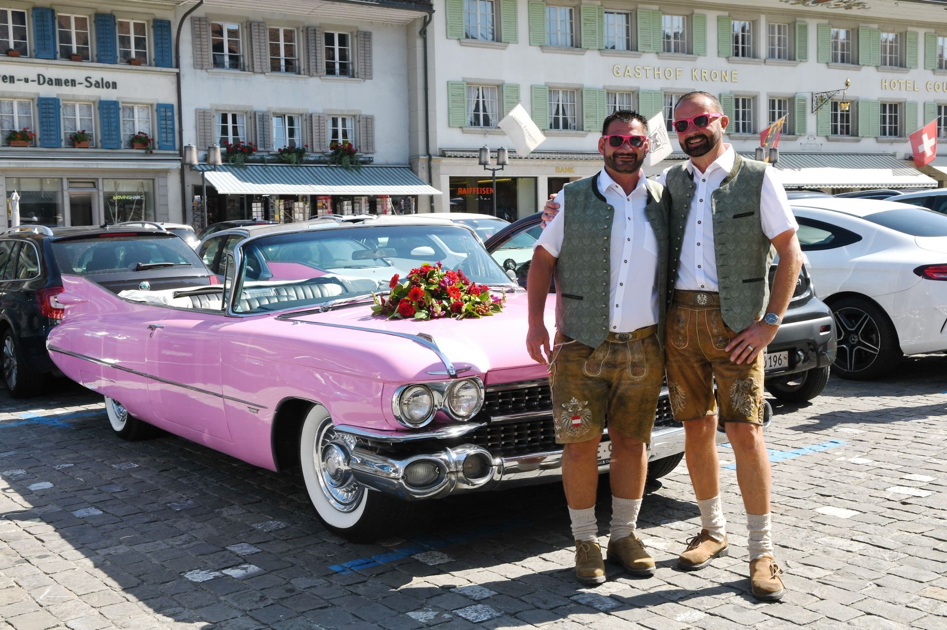 Zwei Bräutigame vor einem Hochzeitsauto bei ihrer Hochzeit