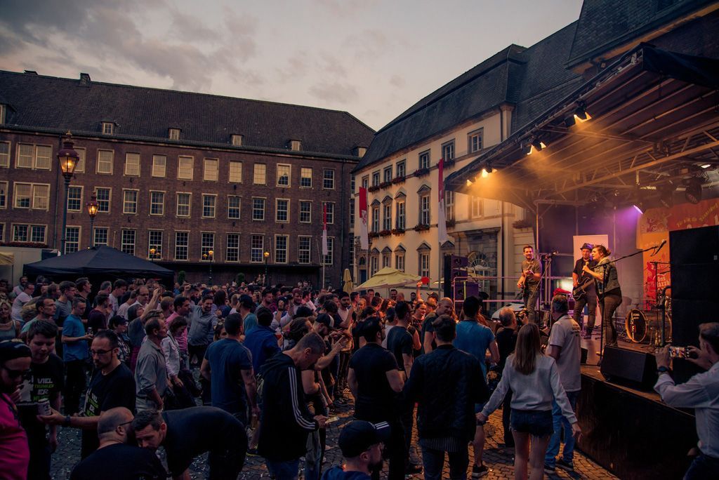 Bei einem Konzert steht eine Menschenmenge vor einer Bühne.