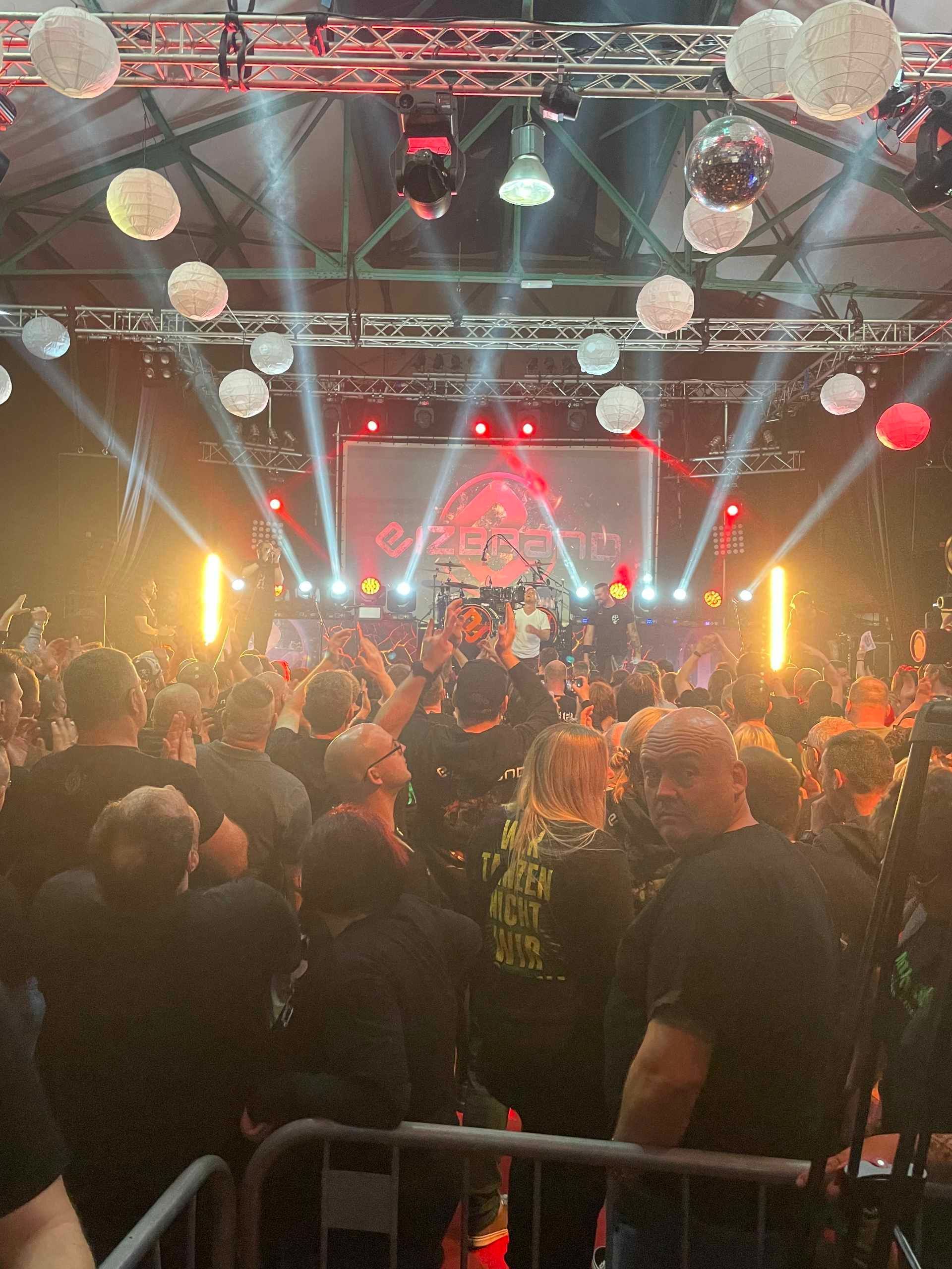 Bei einem Konzert steht eine Menschenmenge vor einer Bühne.