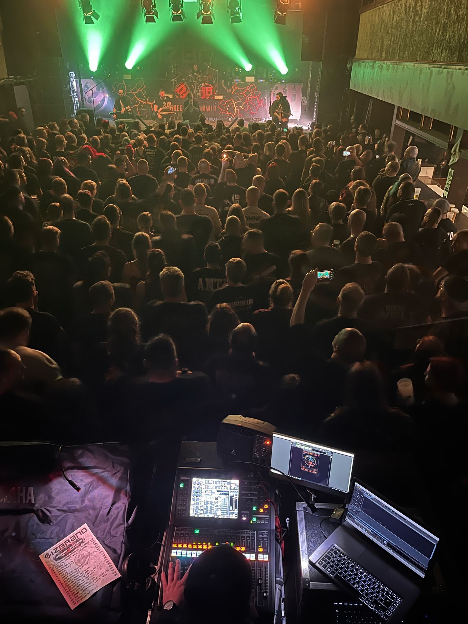 Eine Menschenmenge, die ein Konzert anschaut, im Vordergrund ein Laptop