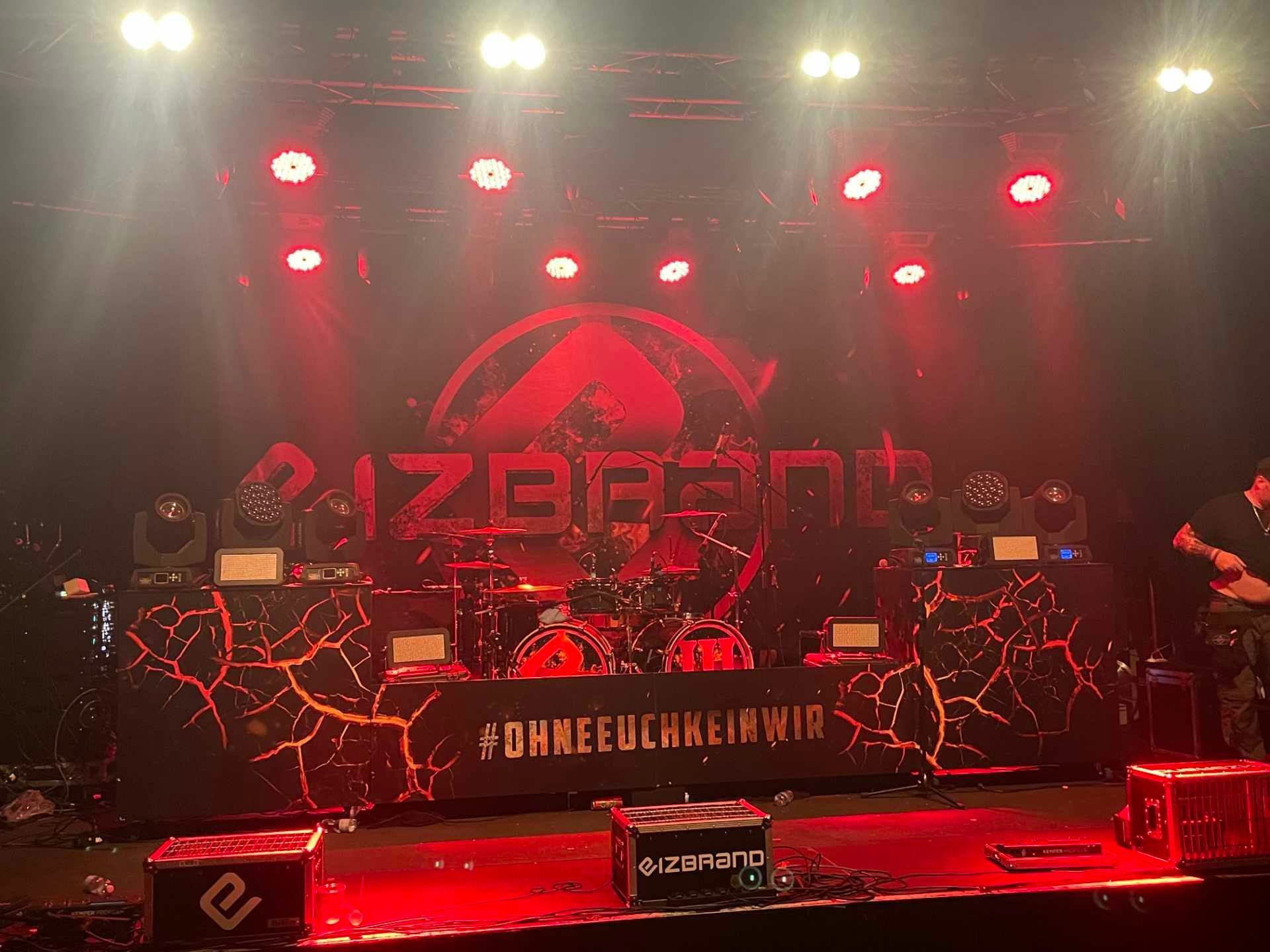 Eine Band gibt ein Konzert auf einer Bühne mit rotem Licht.