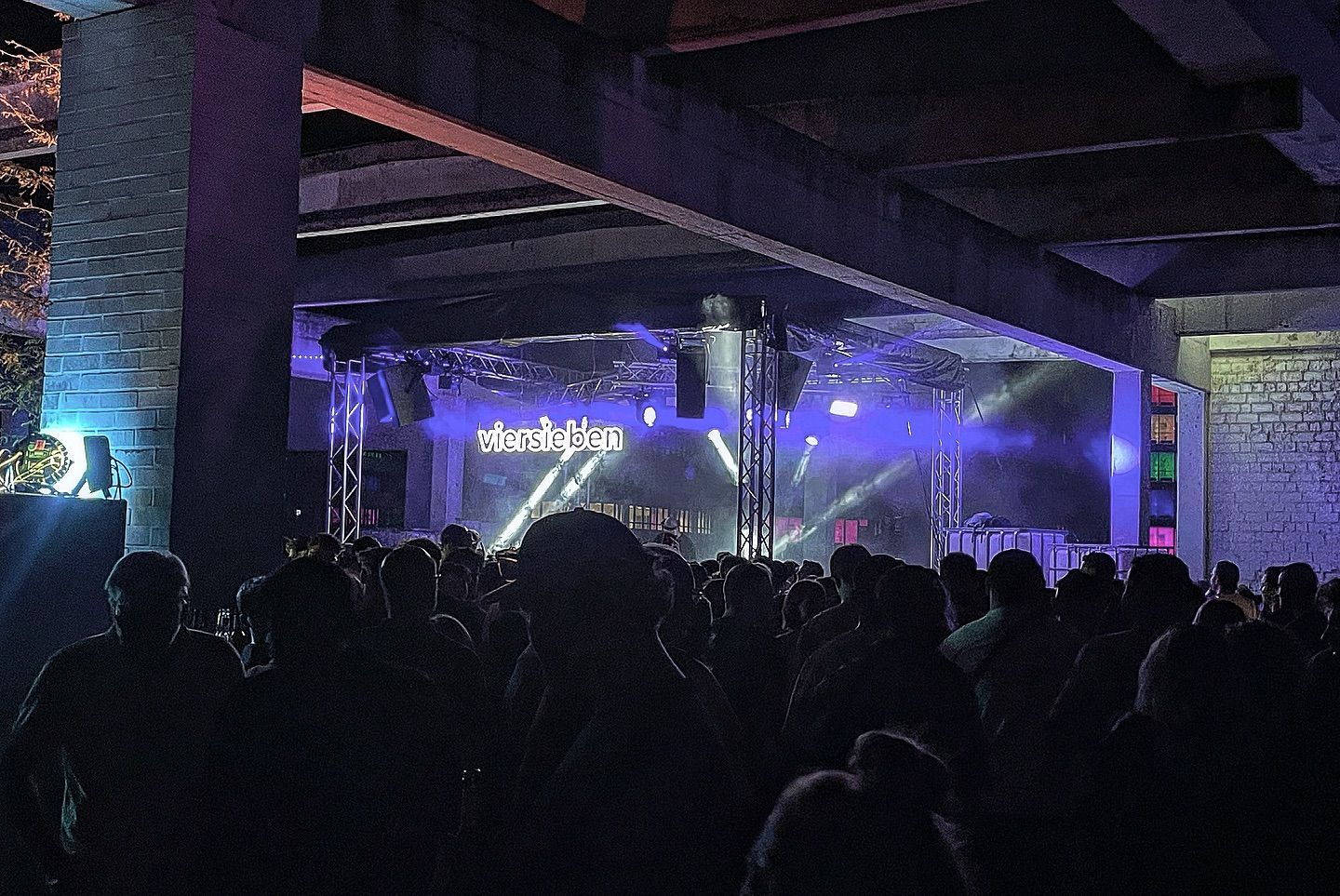 Beleuchtete Bühne mit feiernden Menschen