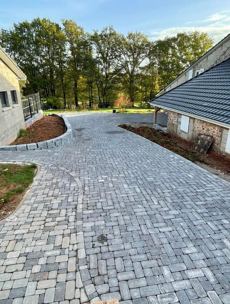 Allée descendante entre deux habitations entièrement pavée.