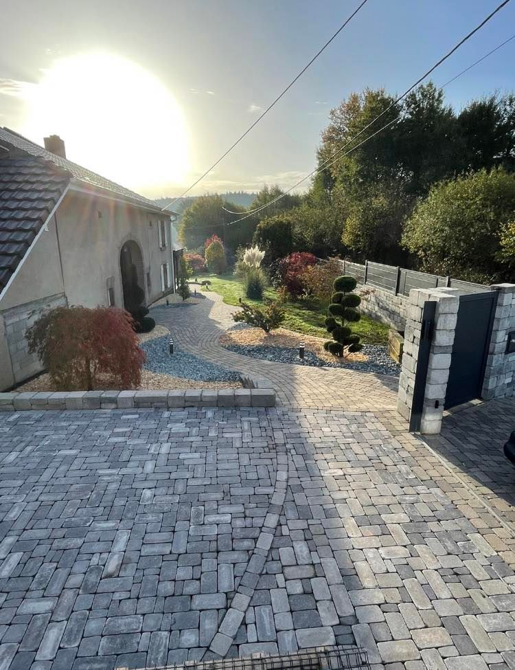 Une très grande allée pavée avec accès vers l'entrée d'une habitation.