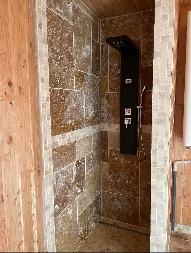 Cabine de douche entièrement carrelée.