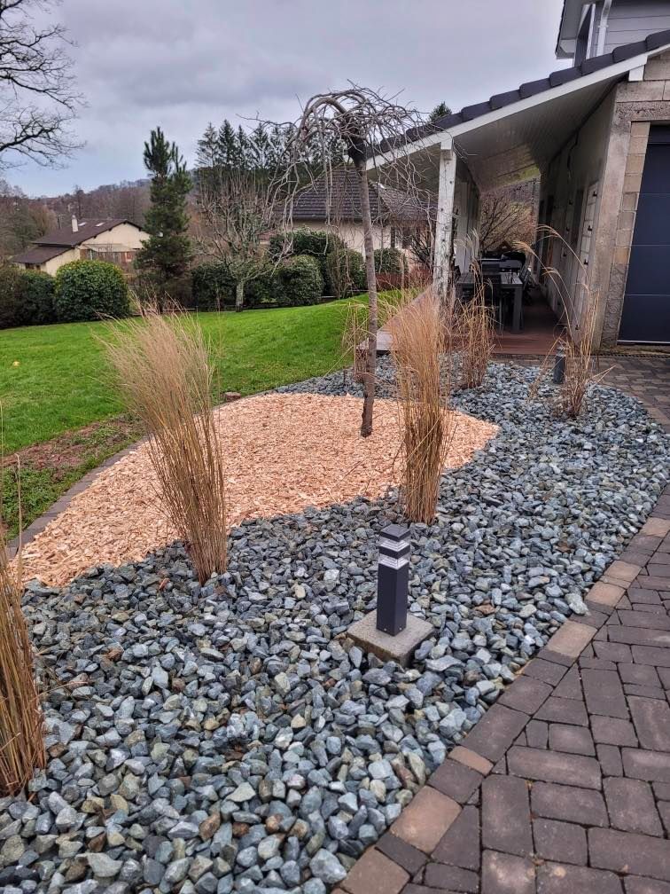 Jardin avec contour de galets le long de l'allée.