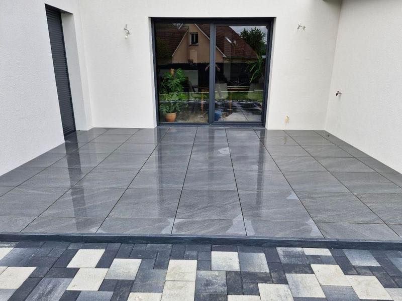 Terrasse carrelée devant une baie vitrée