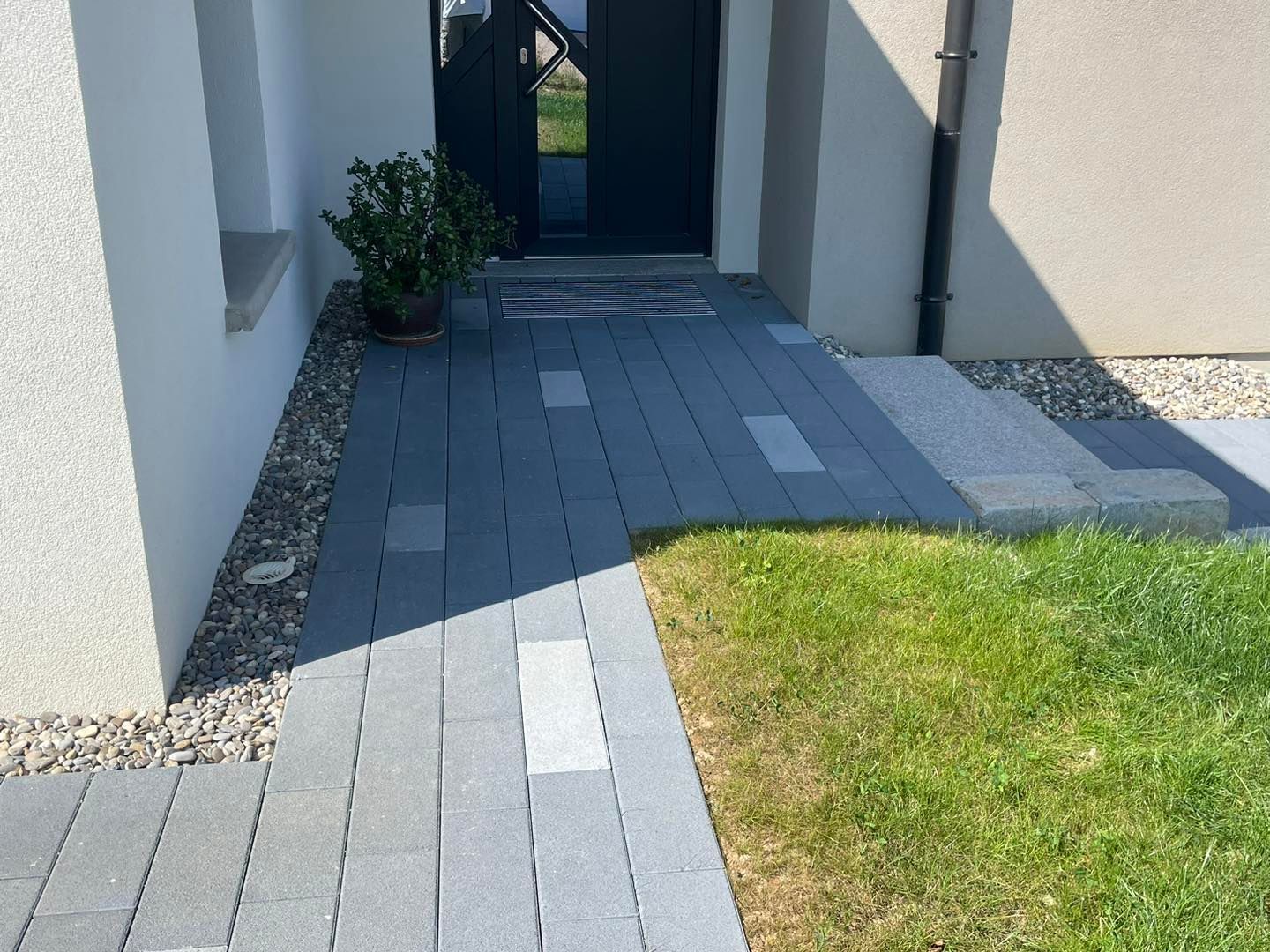 Allée en pavés menant vers la porte d'entrée.