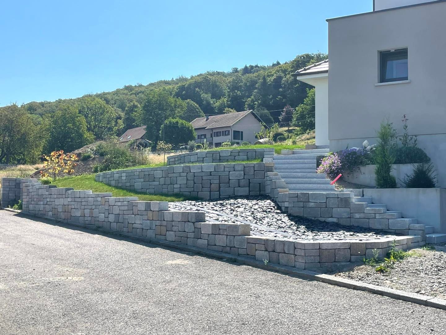 Muret et escalier en pierre menant vers une habitation.