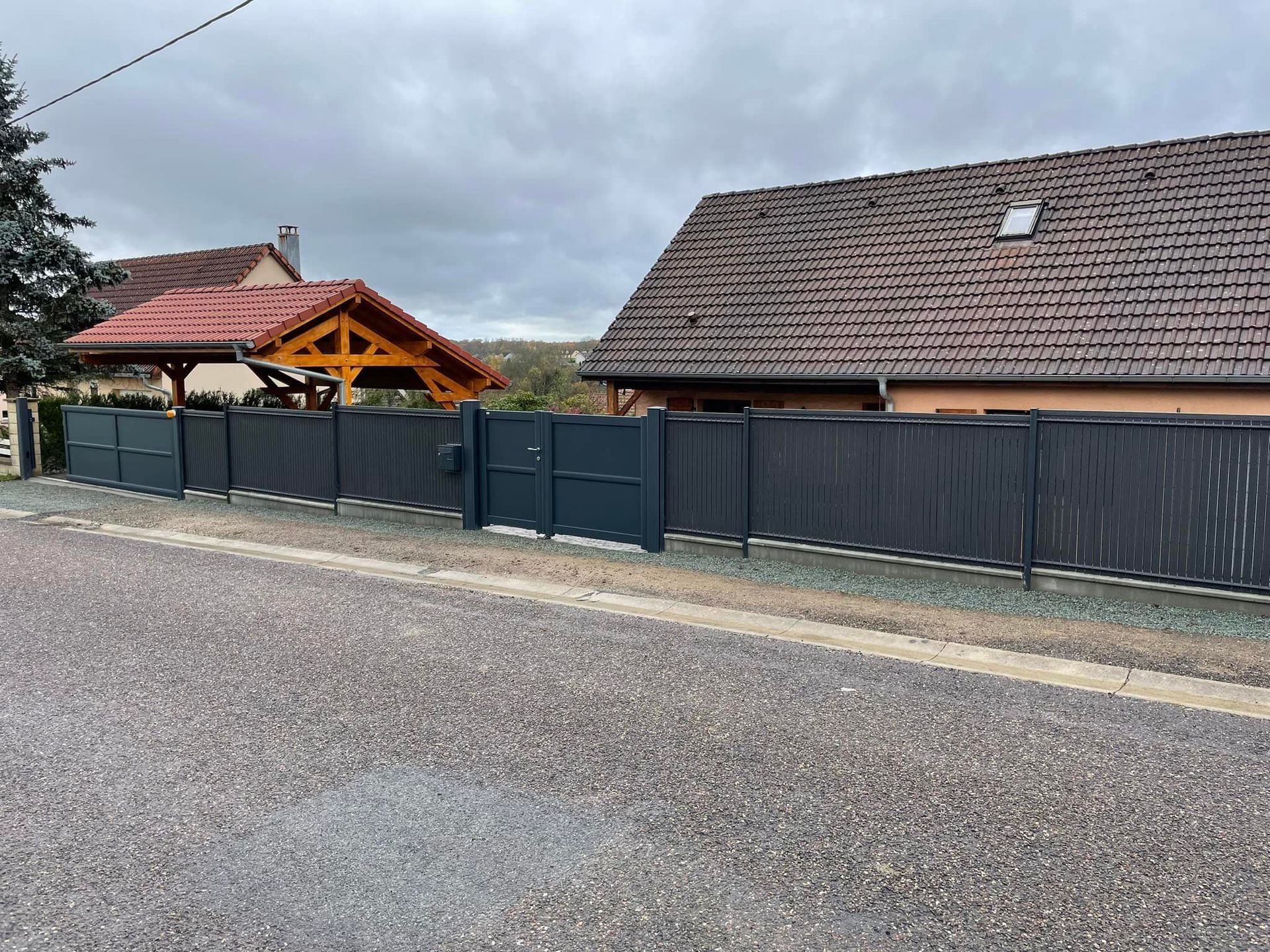 Clôture et portail d'accès le long de la route.