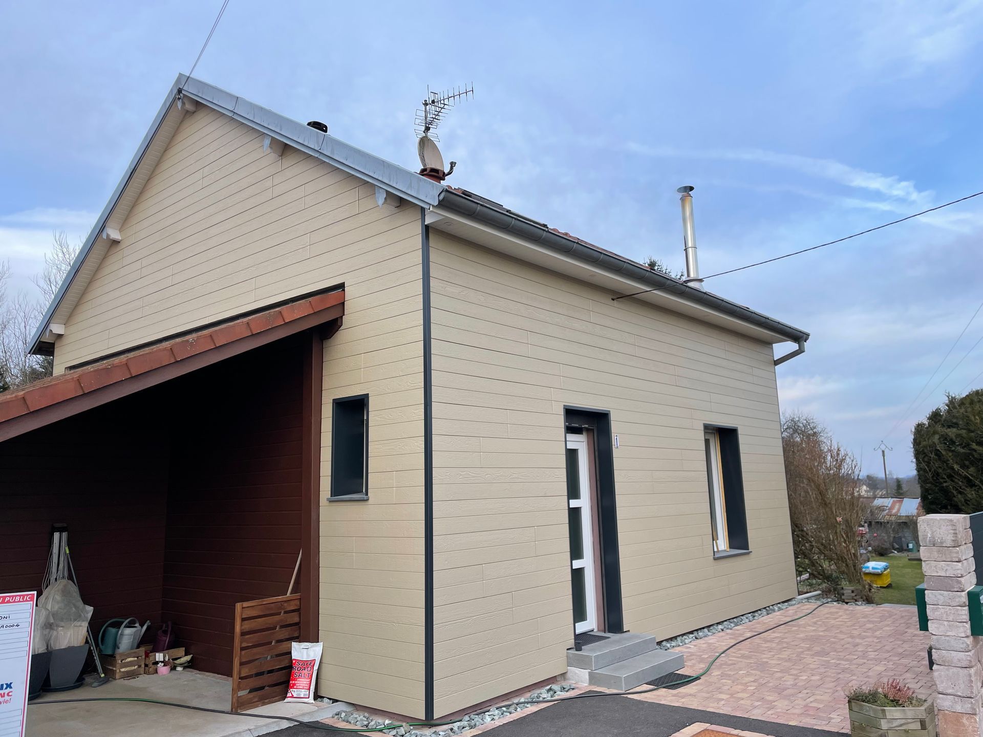 Angle d'une maison individuelle au bardage beige clair.