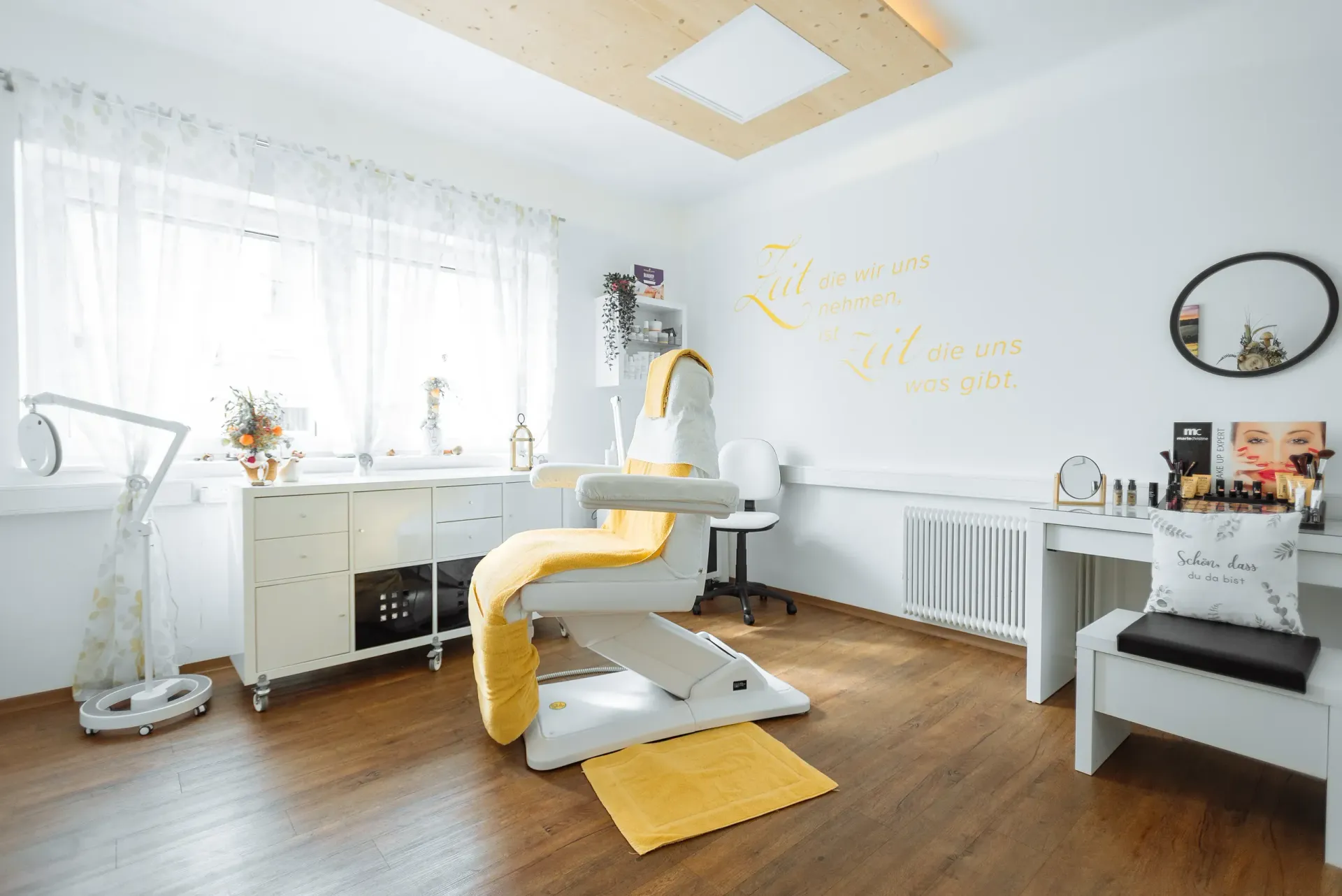 Ein heller Spa-Raum mit weißen Wänden, Holzboden und gelben Akzenten.