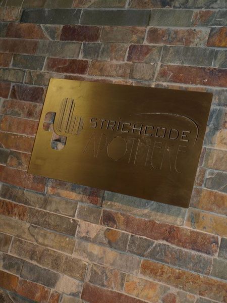 Eine Messingplakette an einer Steinmauer mit der Aufschrift „STROBE“ und einem eingravierten Logo.