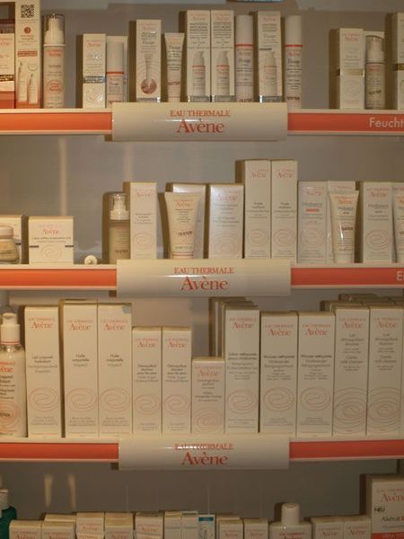 Regale gefüllt mit Avene-Hautpflegeprodukten; weisse Verpackung mit roten Akzenten.
