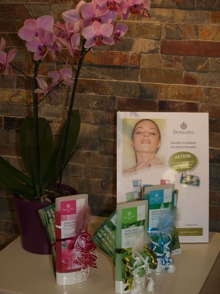 Orchidee mit Präsentation von Schönheitsprodukten vor einer Steinmauer.