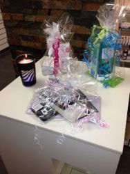 Geschenkkörbe auf einer weissen Theke; enthalten Kerzen und Toilettenartikel, in Zellophan verpackt und mit Schleifen verziert.