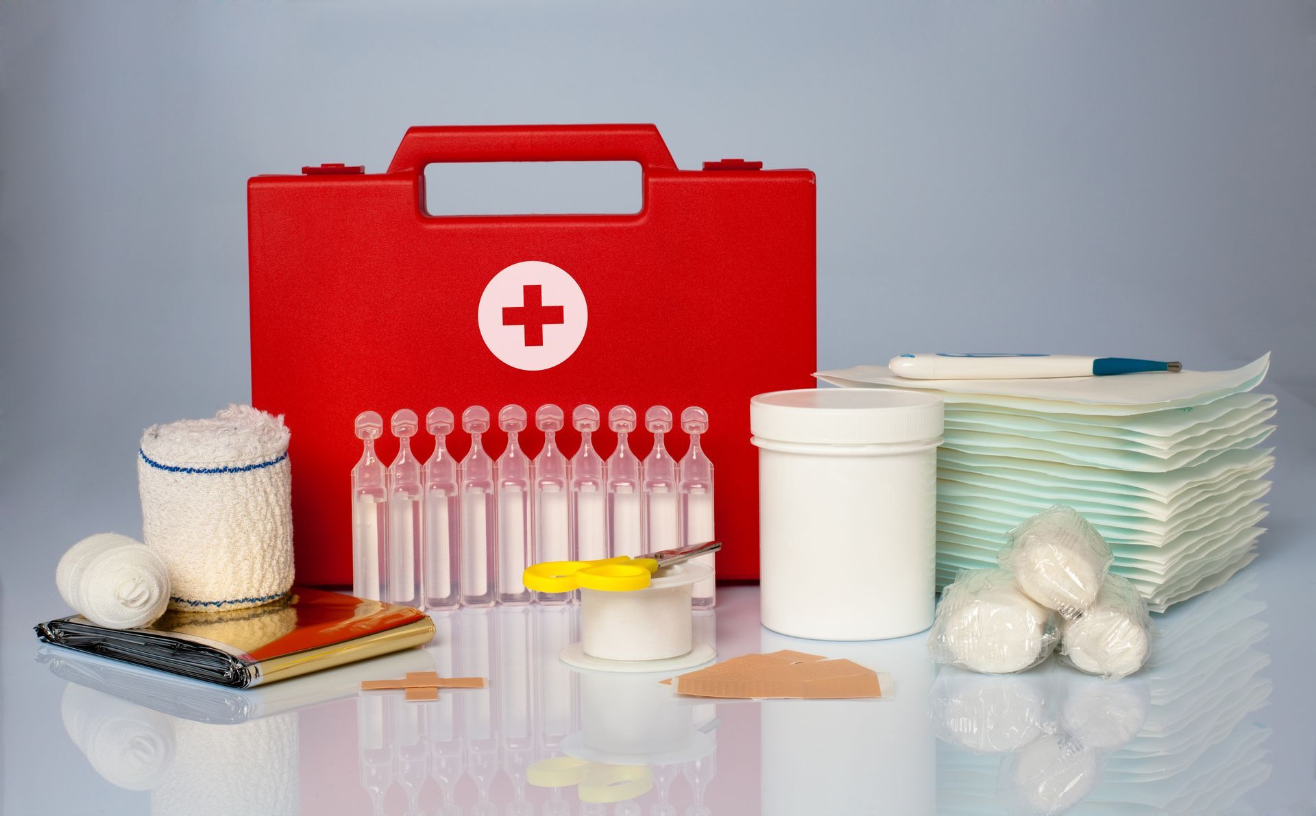 Valisette rouge de premiers soins avec du matériel paramédical posé autour